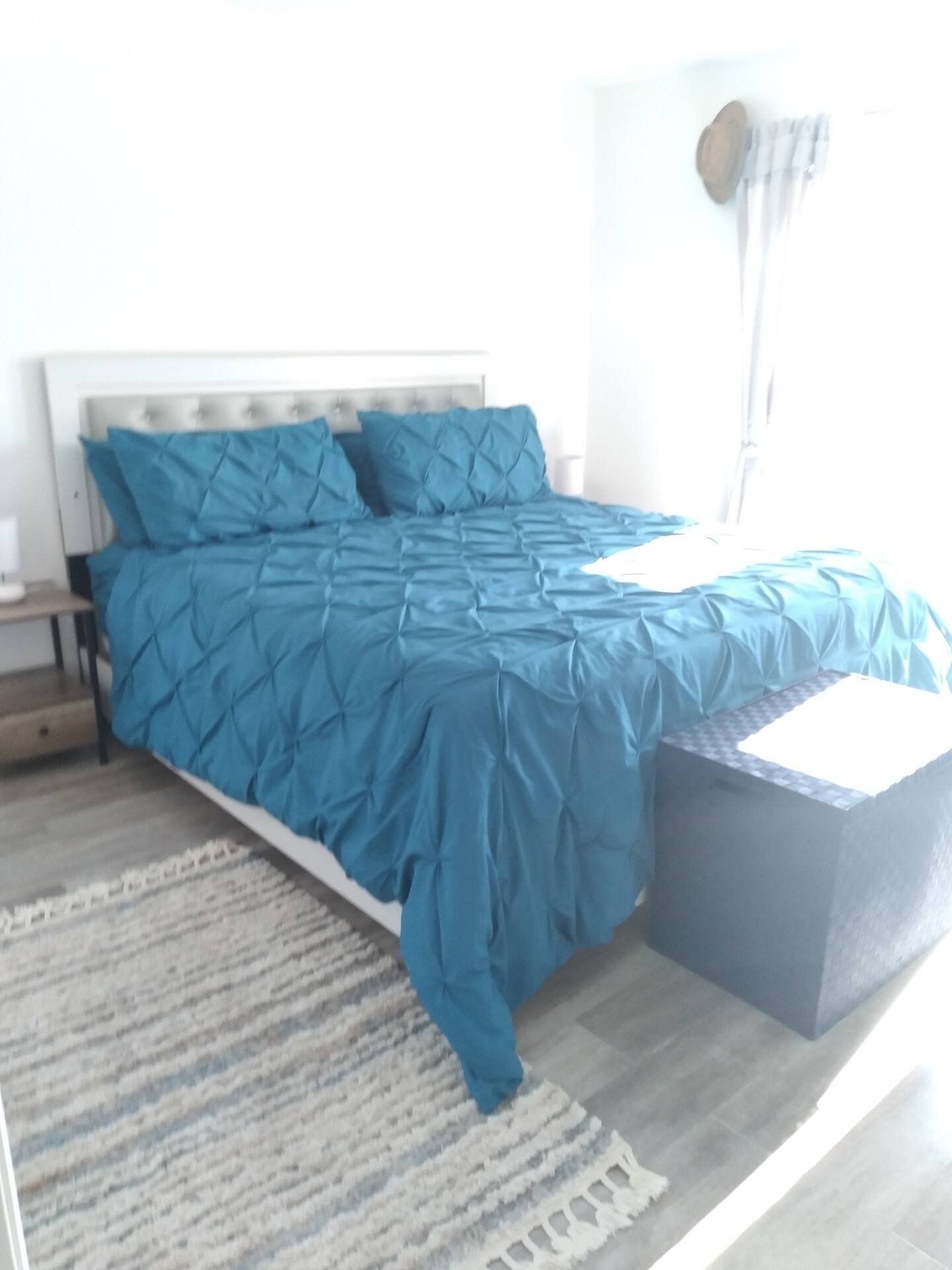 A bed made up in turquoise linen