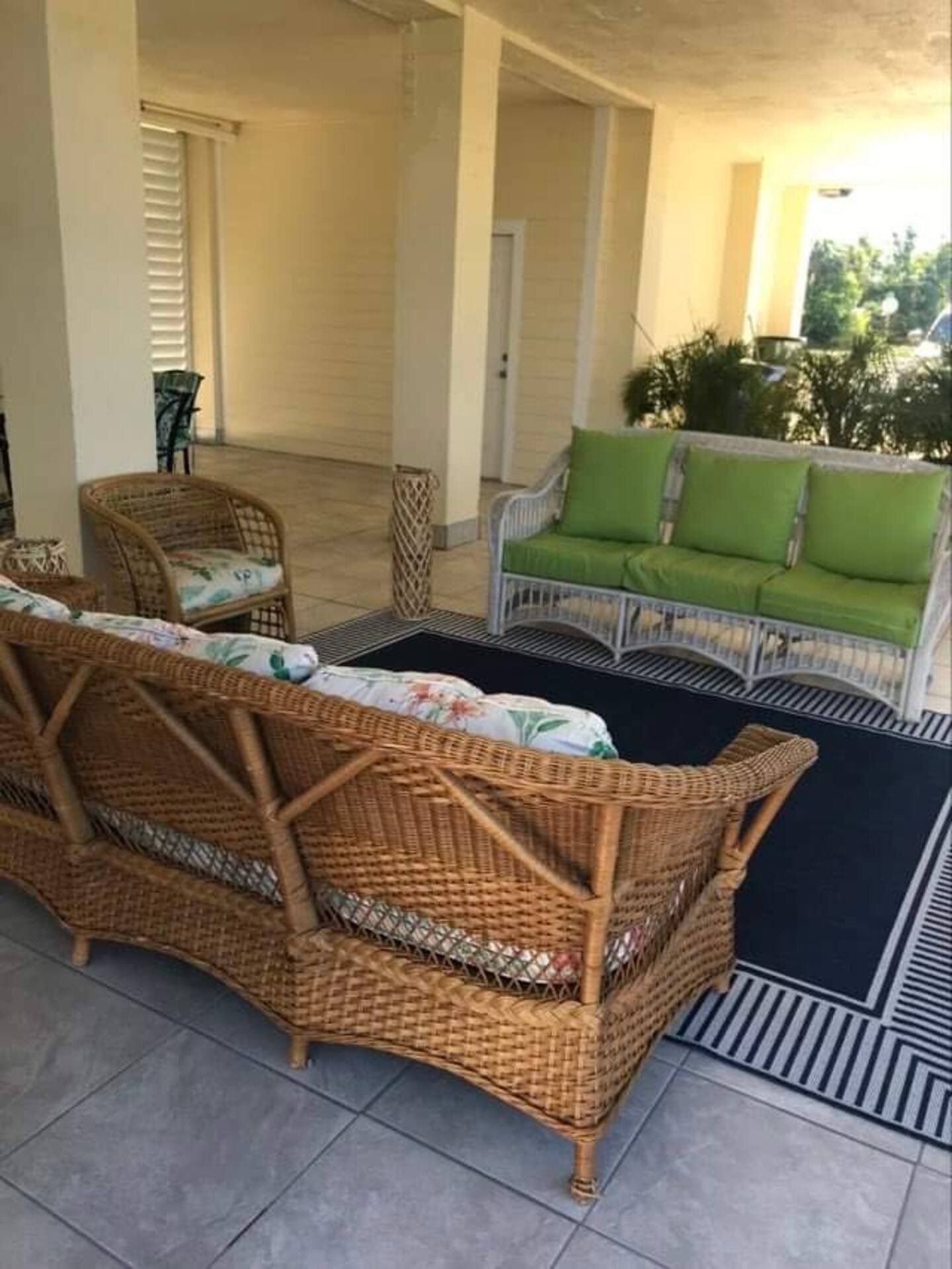 A corner of the patio with wicker chairs and a rug
