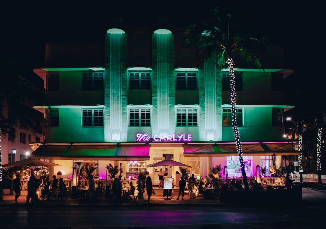 An Art Deco hotel lit up in neon at night
